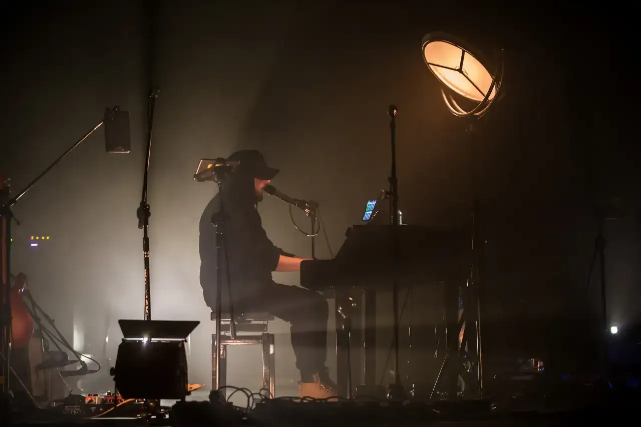 Artysta grający na keyboardzie na scenie. Warto wiedzieć, ile trwa koncert Korteza, by zaplanować wieczór.